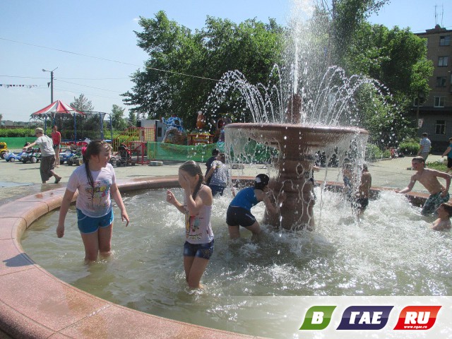 Дети купаются в фонтане