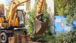Женщинам с колясками рабочие помогают перебраться через грязь